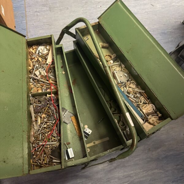 Vintage metal cantilever toolbox filled with hardware.