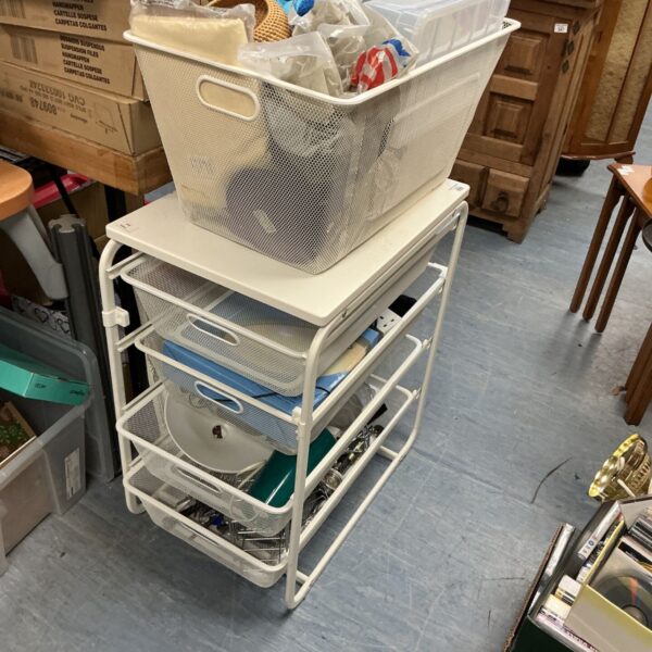 White metal kitchen storage unit filled with kitchen items.