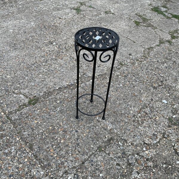 Dark metal tiered plant stand for garden display.