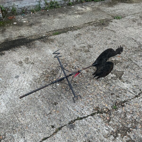 Vintage metal rooster weather vane for garden decoration.
