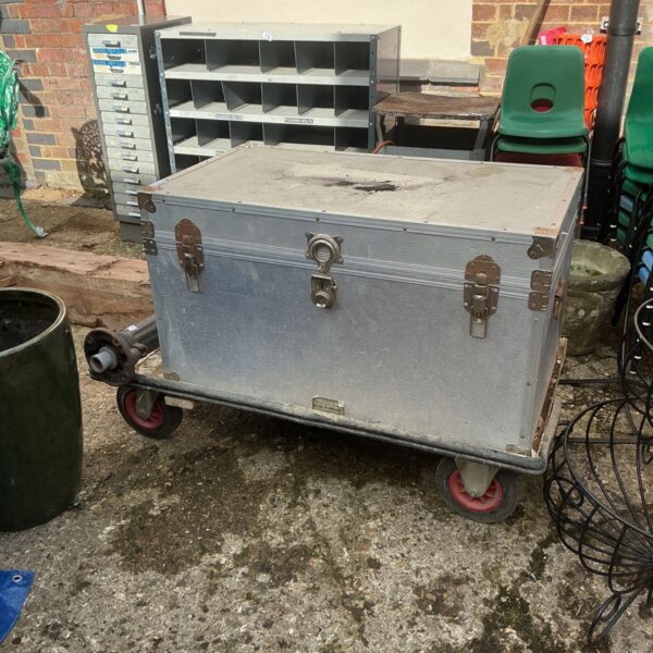 Vintage metal storage box on wheels, ideal for tools.