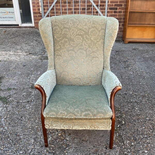 Vintage mid-century armchair with green and gold floral upholstery.