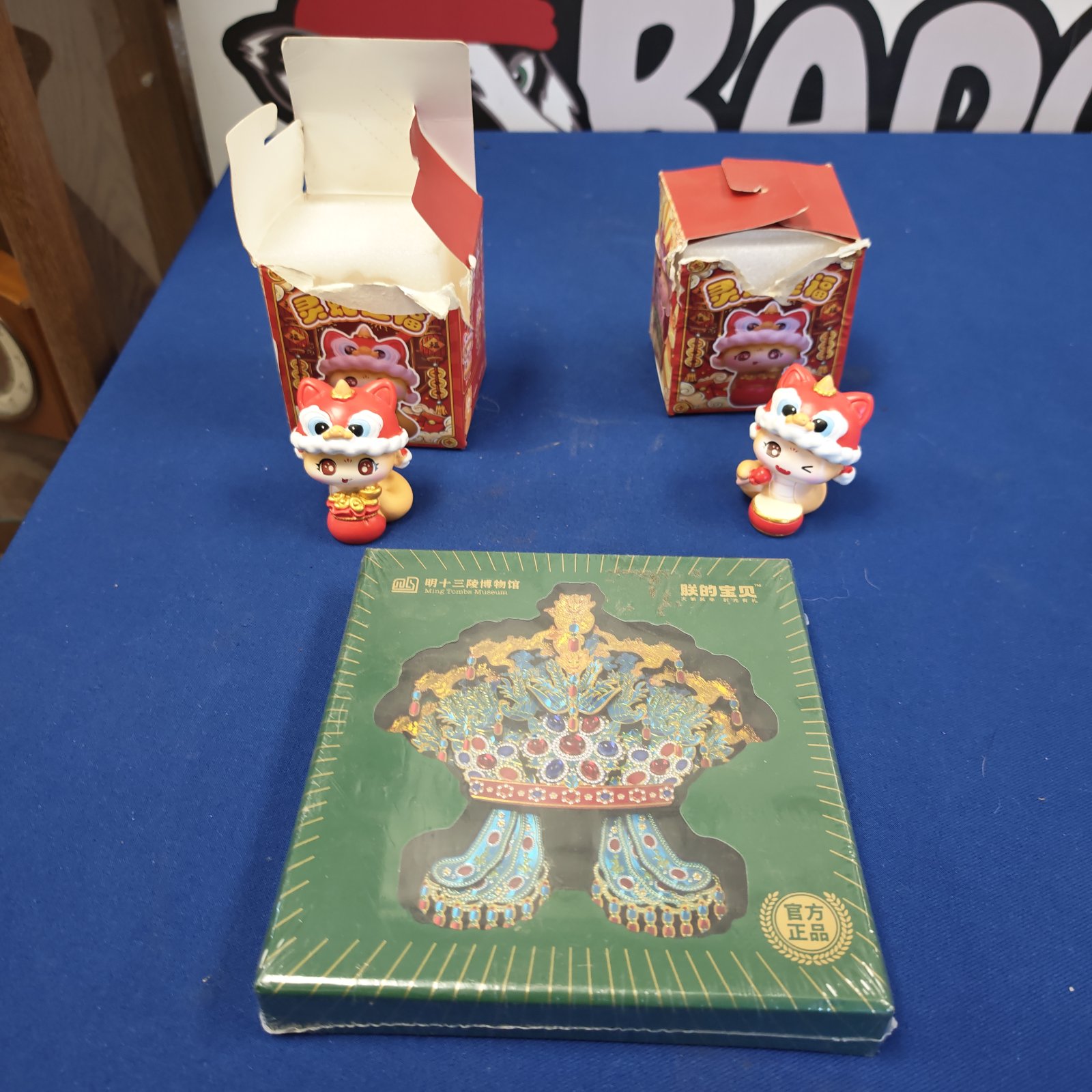 Intricate Ming Dynasty ceremonial hat with two collectible figures displayed.