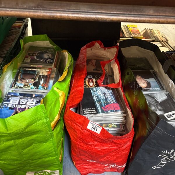 Three bags filled with a mixed CD collection for sale.