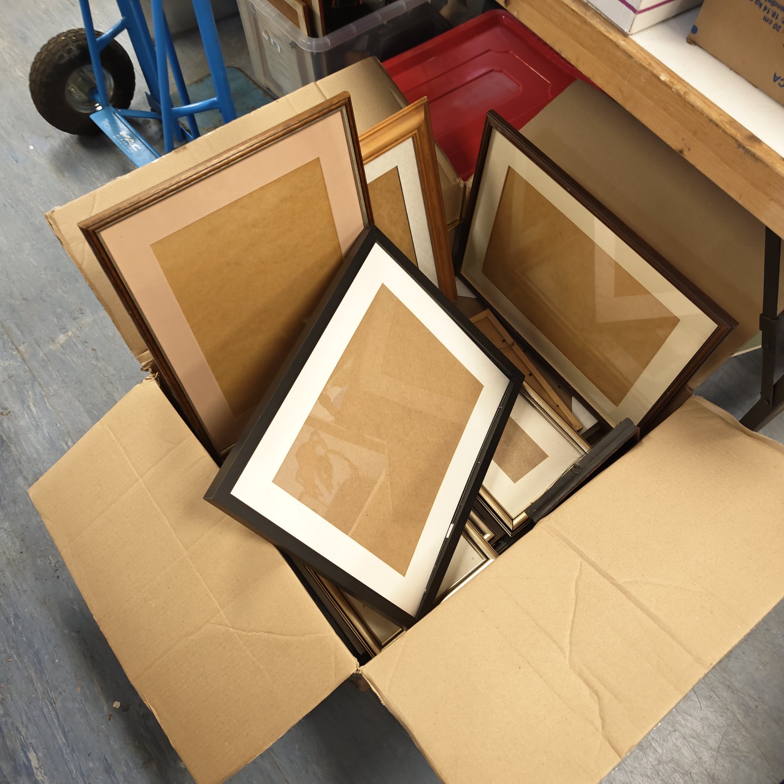 Large lot of assorted picture frames in a cardboard box.