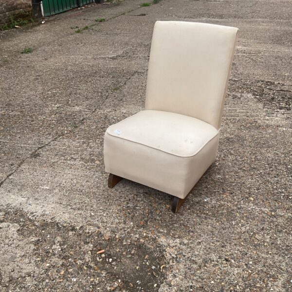 Vintage modernist easy chair with wooden legs and neutral upholstery.