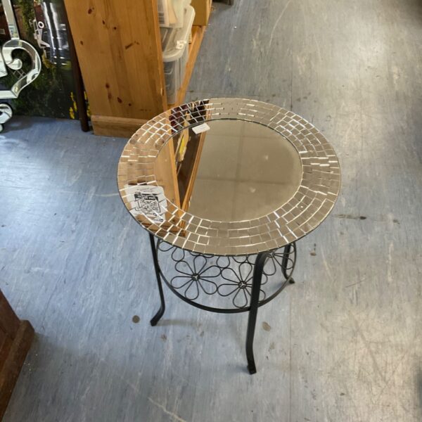 Round mosaic mirror table with dark metal frame.