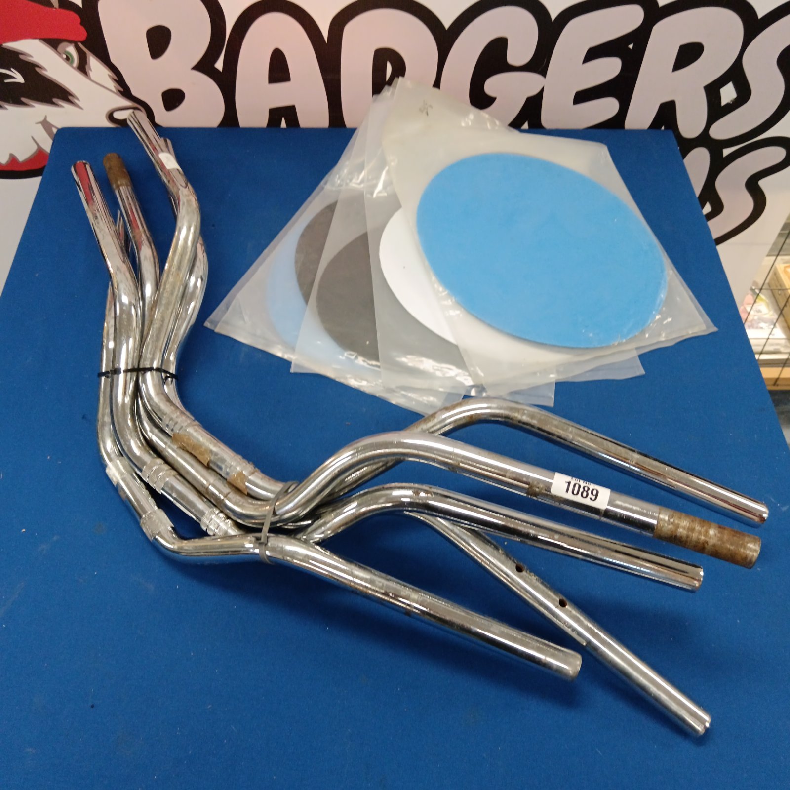 Chrome motorcycle handlebars and plastic motocross number plates.