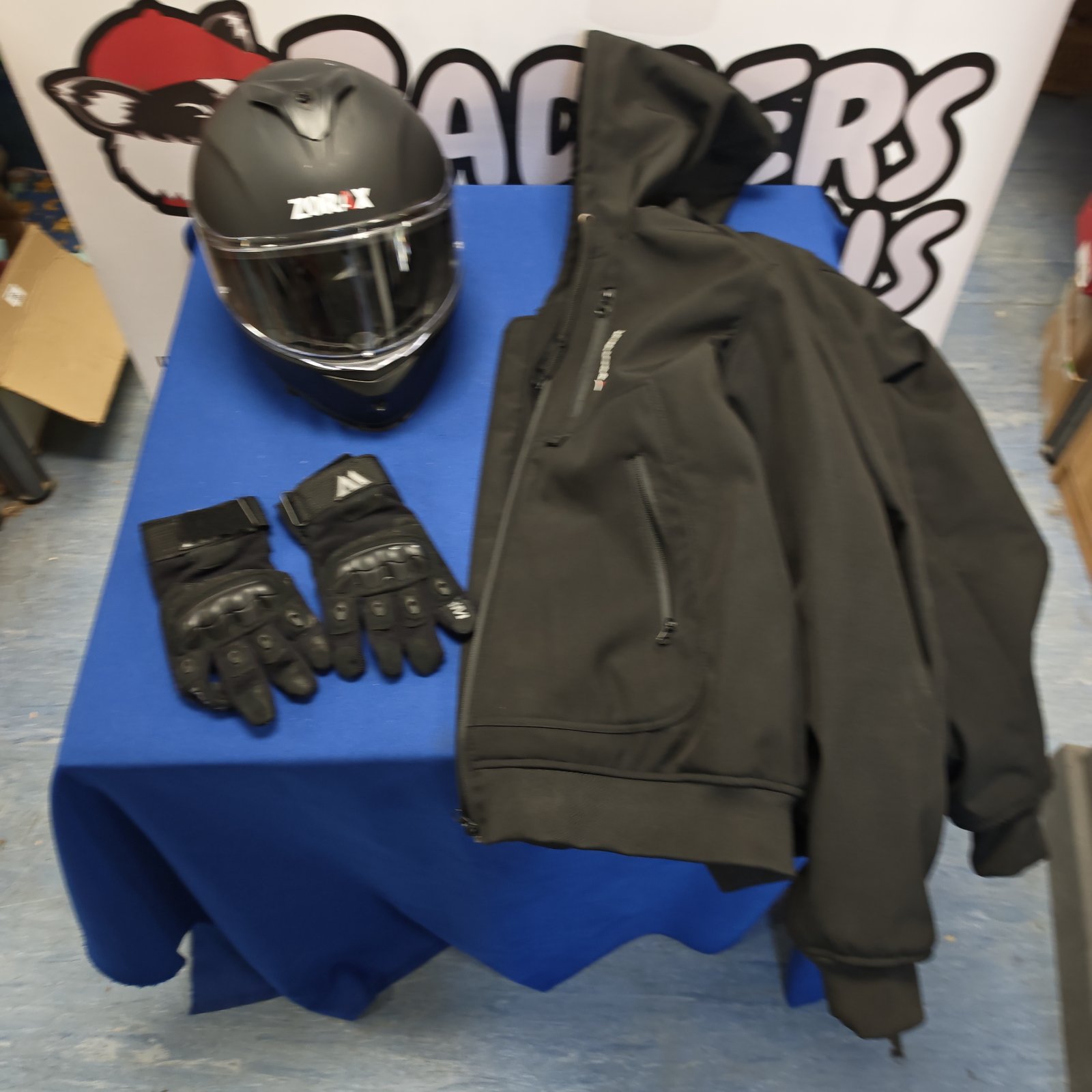 Motorcycle helmet, gloves, and padded jacket set for riding safety.