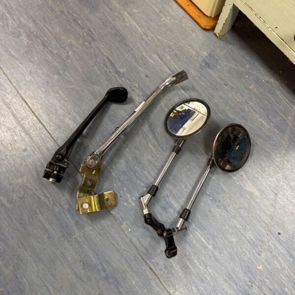 Vintage motorcycle side stands and chrome mirrors for restoration.
