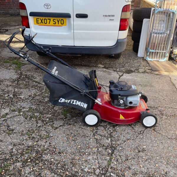 Used Mountfield petrol lawnmower in a garden setting.