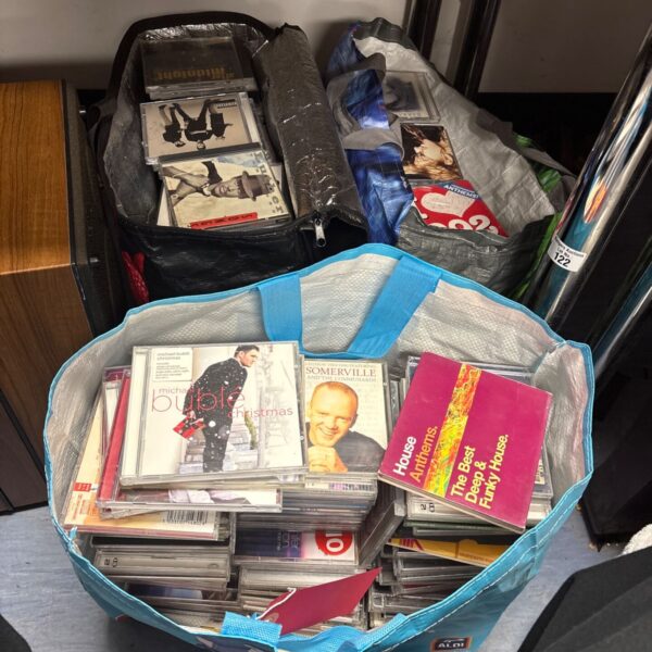Mixed music CD lot in bags, diverse collection of audio discs.