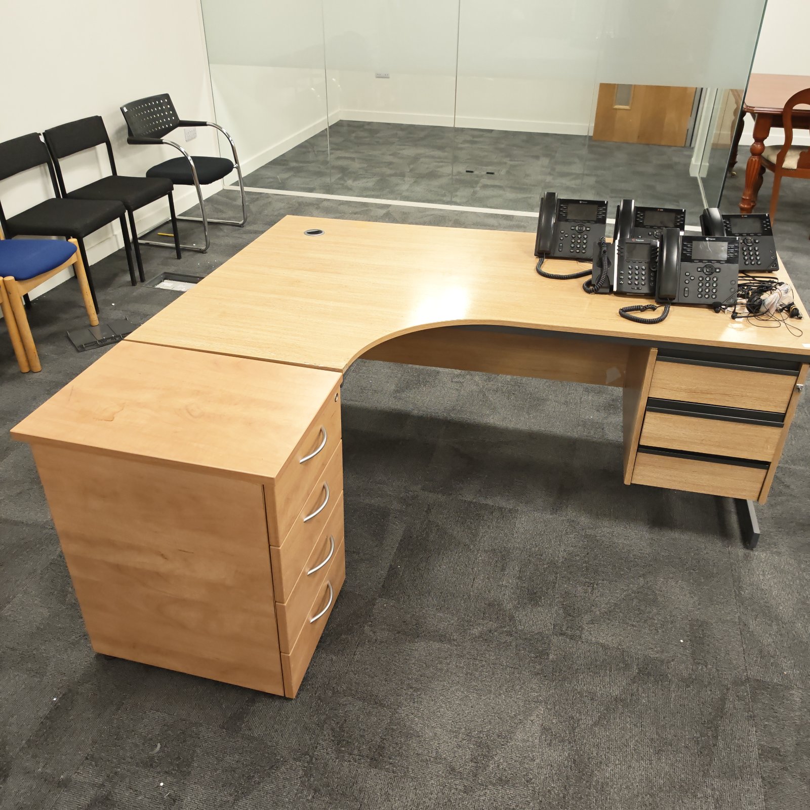 Vintage office desk with telephones and storage drawers.