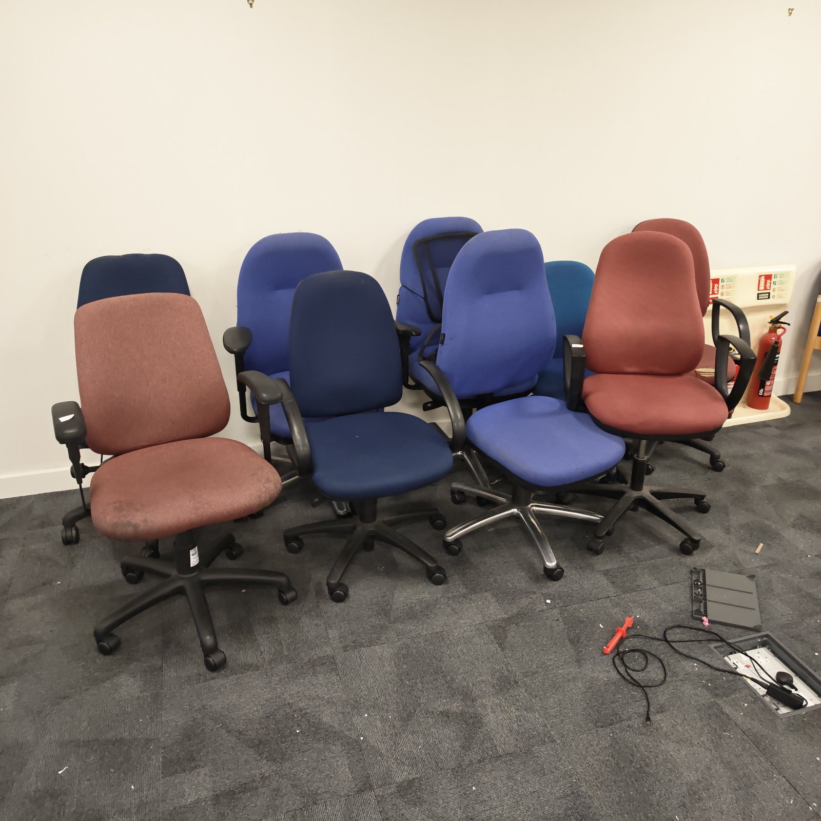 Bundle of used office swivel chairs in blue and red.
