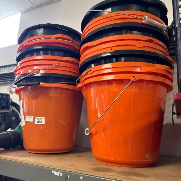 Stack of new orange plastic buckets for storage and utility.