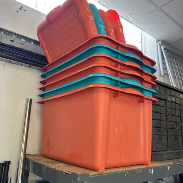 Stack of orange and teal plastic storage boxes for household organization.