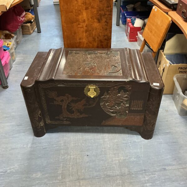 Antique oriental carved coffer with detailed floral and dragon motifs.