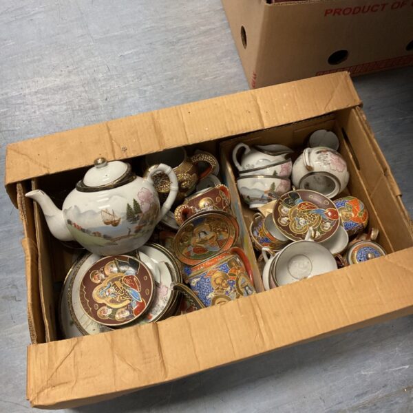 Tray of vintage oriental teasets with patterned porcelain.