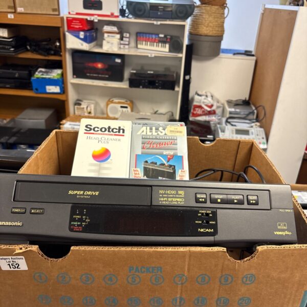 Vintage Panasonic HD90 VCR with accessories in a cluttered space.