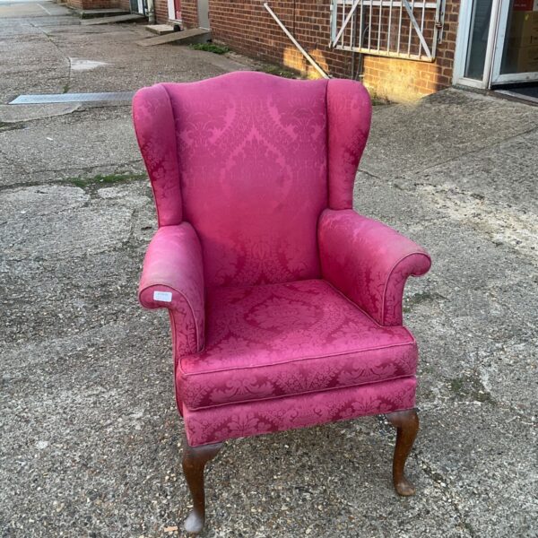 Red Parker Knoll wingback armchair with cabriole legs.
