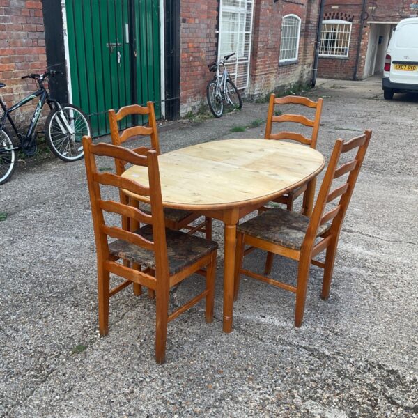 Vintage pine dining table with four chairs in a garden setting.