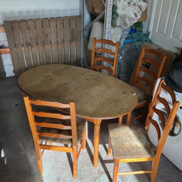 Rustic pine dining table and four chairs in a country kitchen setting.