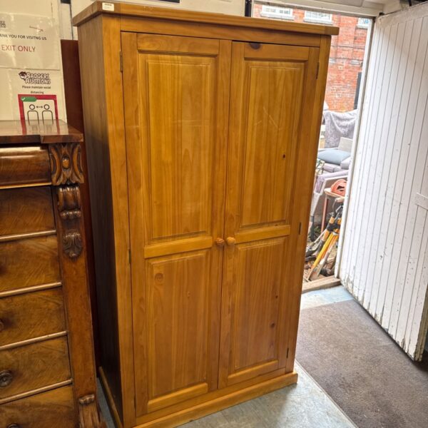 Light wood pine wardrobe with two doors, ideal for bedroom storage.