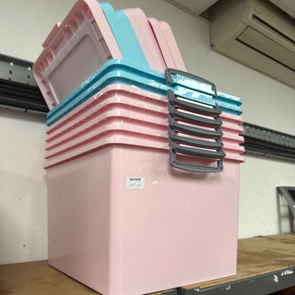 Stack of pink plastic storage boxes with lids for home organisation.