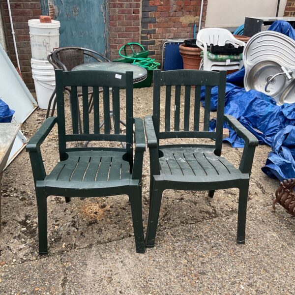 Pair of weathered plastic garden chairs for outdoor use.