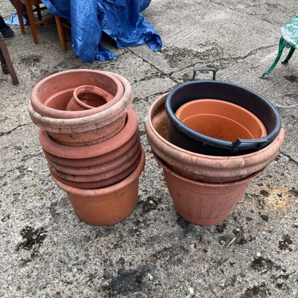 Assorted plastic garden pots stacked for storage.