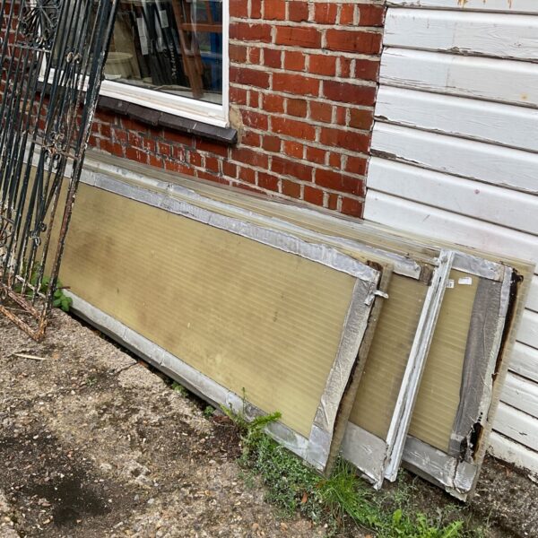 Four used plastic roofing sheets in a garden setting.
