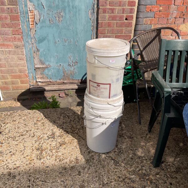 Lot of empty blue plastic storage tubs for garden or home use.