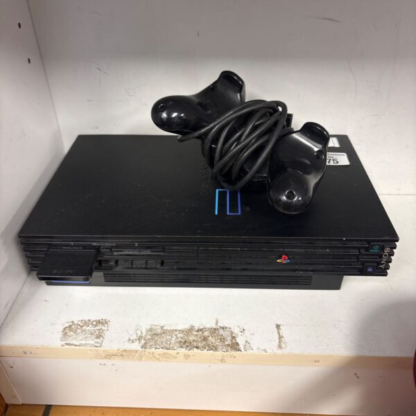 Black Sony PlayStation 2 console with controller and cables.