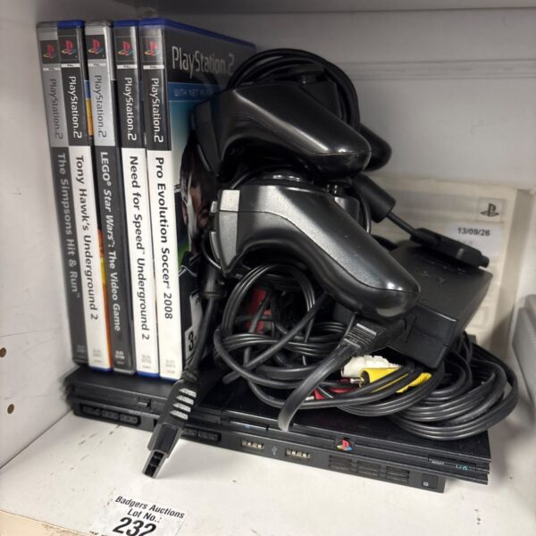 Sony PlayStation 2 slim console with games and controllers.