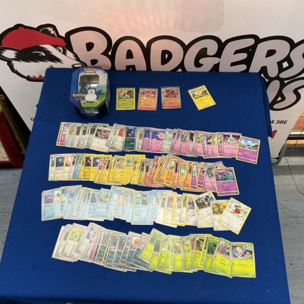 Assorted Pokémon cards inside a Pokémon Go collectors tin.