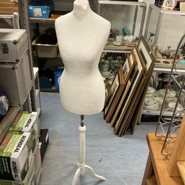 Polystyrene manikin on wooden tripod stand for clothing display.