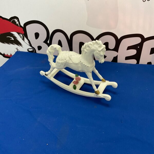 Vintage porcelain rocking horse figurine with floral details.