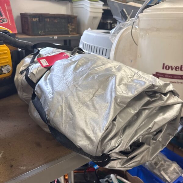 Silver Porsche car cover for vehicle protection and storage.