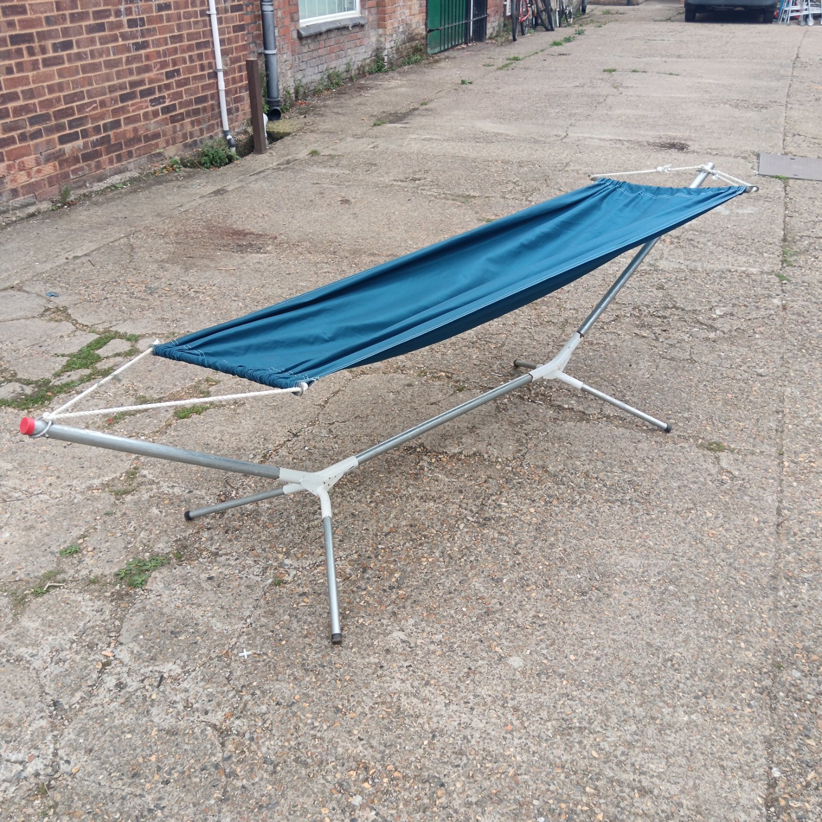 Blue portable hammock with aluminium frame, ideal for outdoor use.