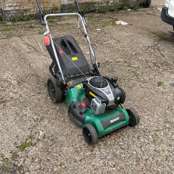 Used Qualcast petrol lawnmower in a garden setting.