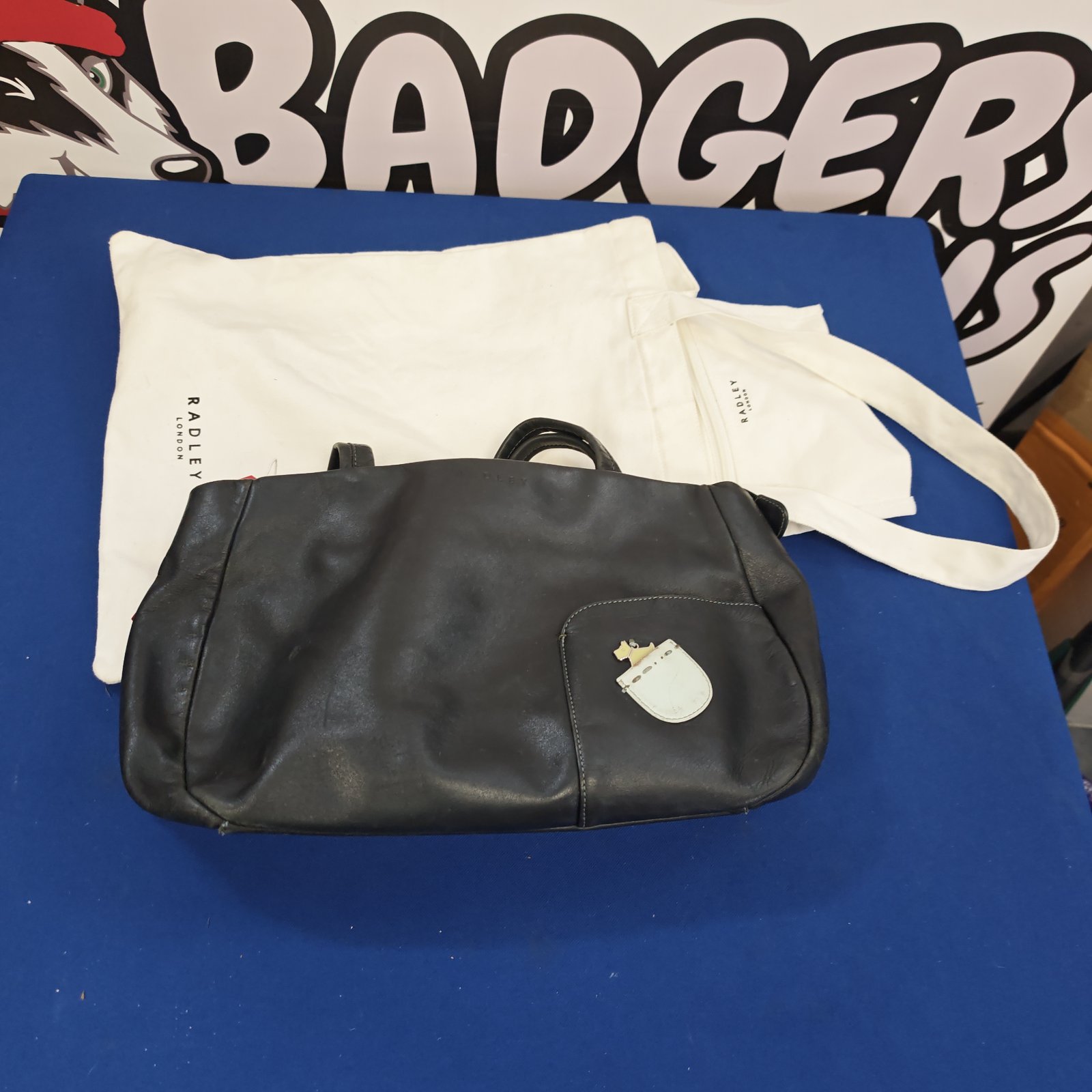 Black leather Radley handbag with dust bag, a stylish fashion accessory.
