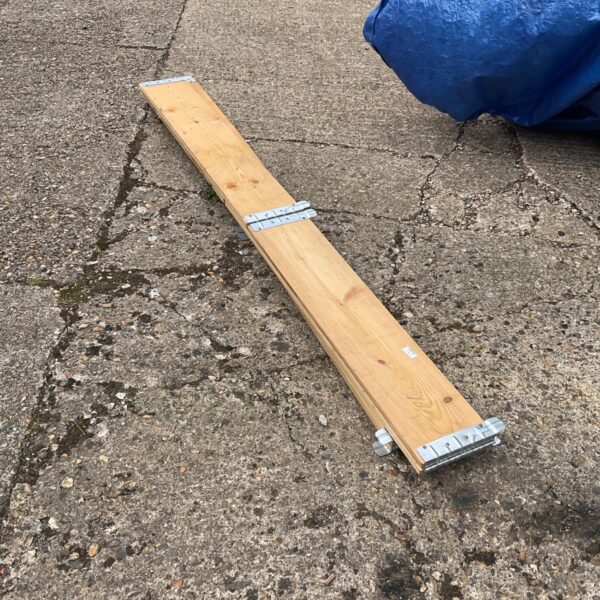 Wooden raised garden bed border with metal brackets.