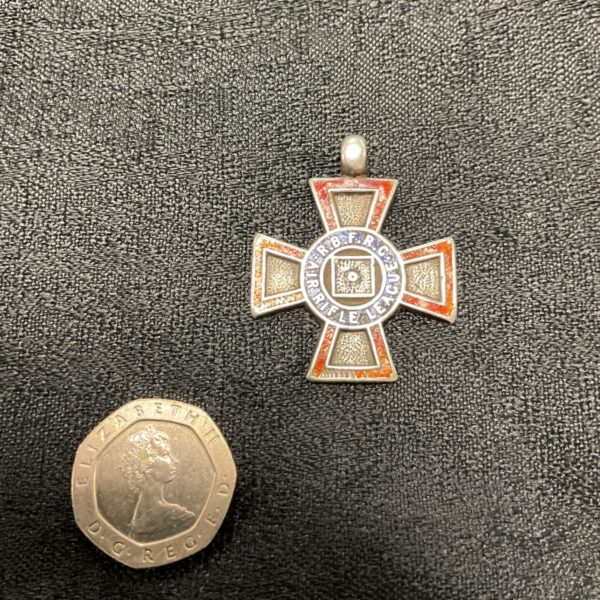 Silver RBFRC Air Rifle League medal with a coin for scale.