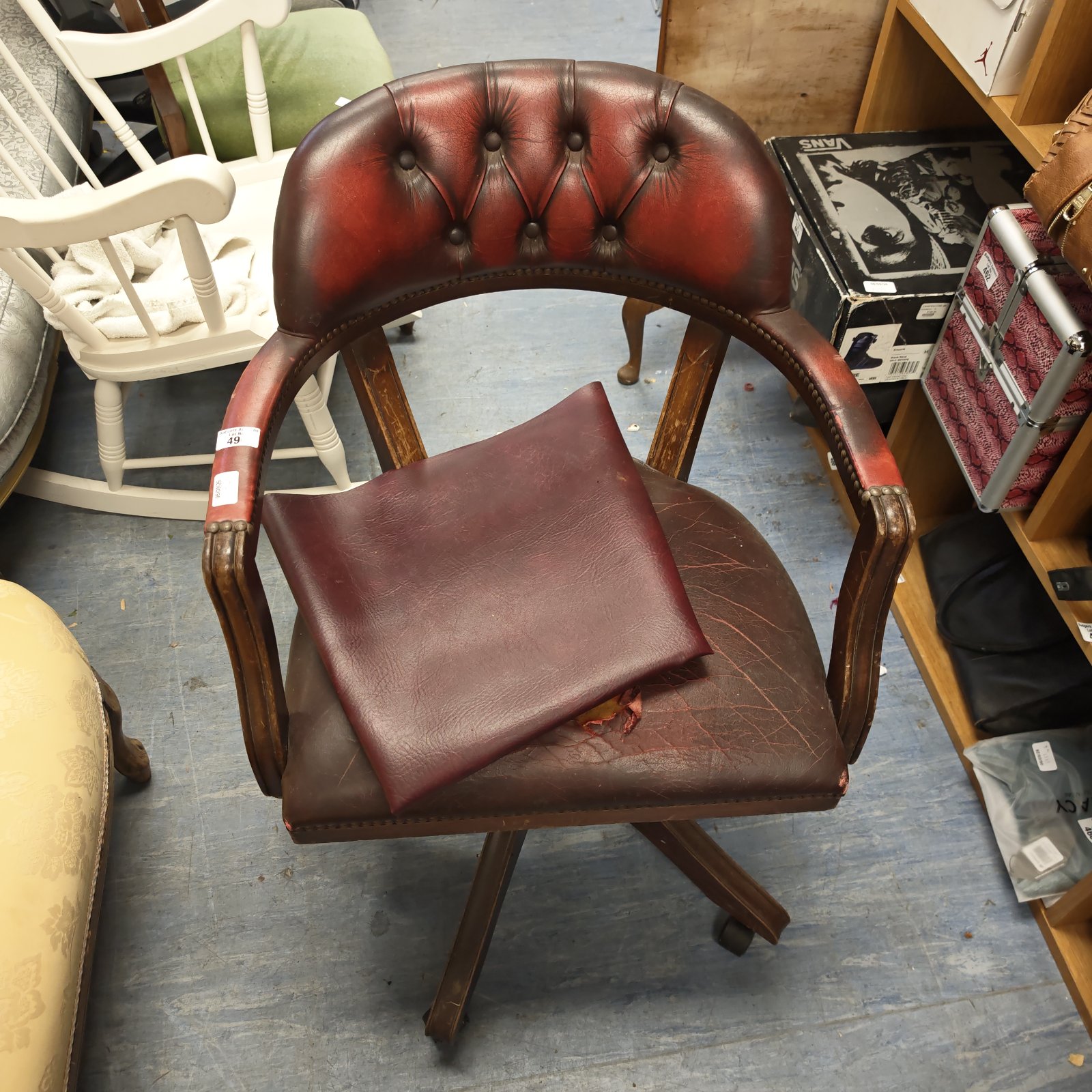 Vintage red leather captains chair with wooden frame.