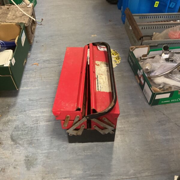 Red metal cantilever toolbox for tool storage, showing signs of wear.