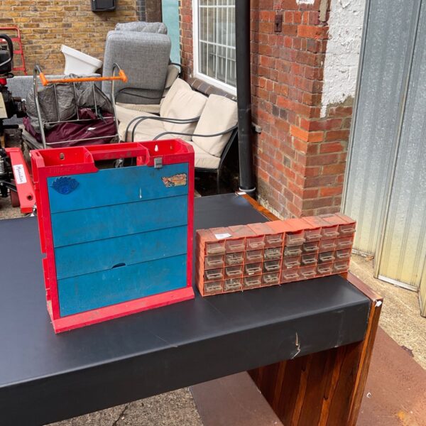Red plastic nuts and bolts storage unit with multiple drawers.
