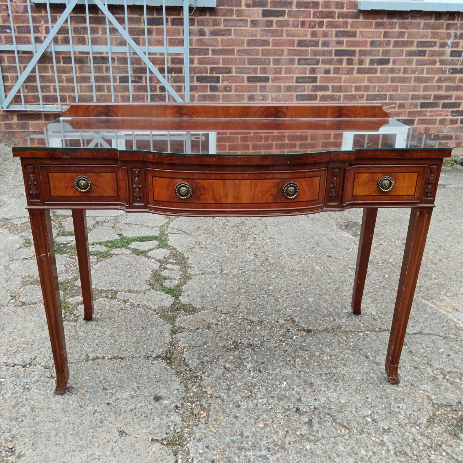 Regency style mahogany sideboard with glass top and drawers.
