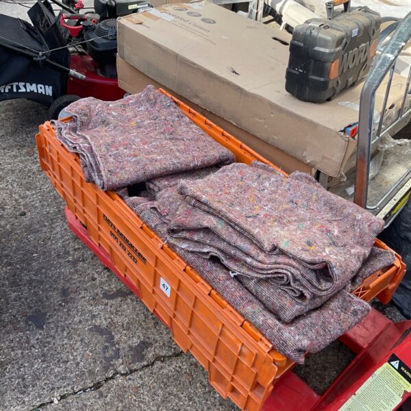 Crate filled with removal blankets and dust sheets for furniture protection.