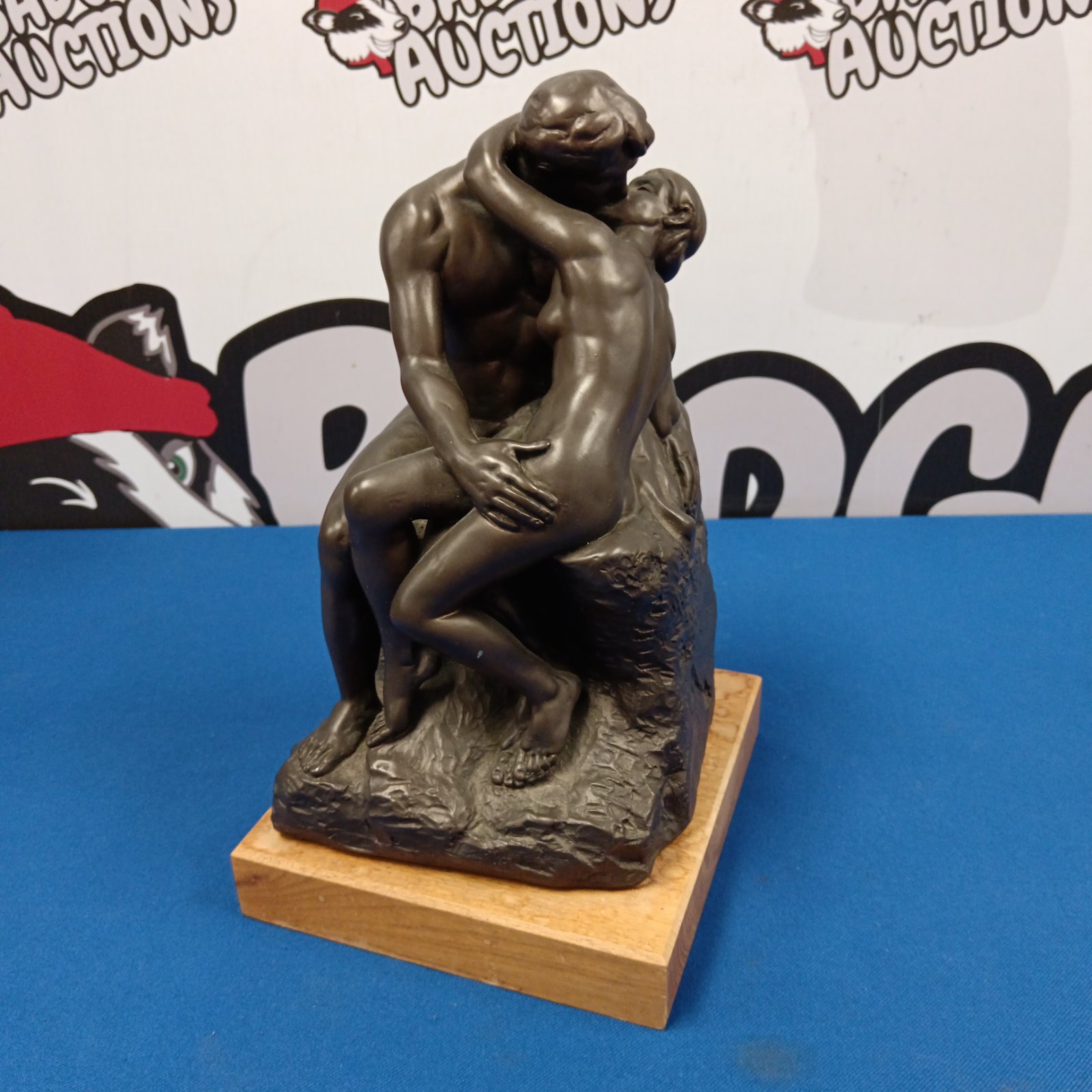 Austin reproduction of Rodin’s “The Kiss” sculpture on wooden base.