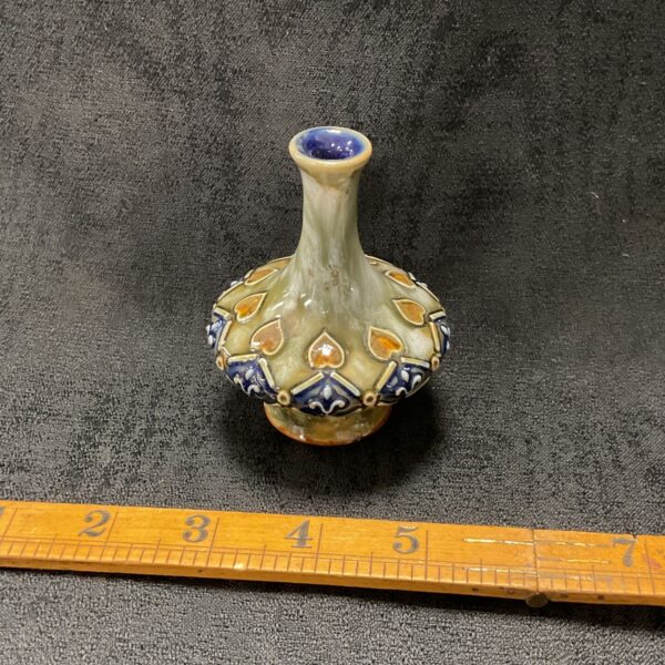 Royal Doulton miniature vase with floral design and ruler for scale.